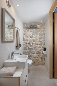 łazienka z umywalką i kamienną ścianą w obiekcie Apartment Stone House Krk w Krku +28 zdjęć