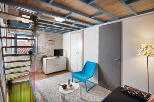 a living room with a blue chair and a table at Apartment Stone House Krk in Krk