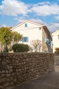 a stone wall in front of a house at Apartment Stone House Krk in Krk