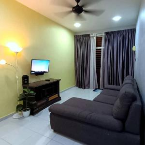 un soggiorno con divano e TV a schermo piatto di Ebnur Homestay ad Arau