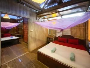 Banlung的住宿－Backpacker Hostel and Jungle Trekking，卧室配有床和蚊帐