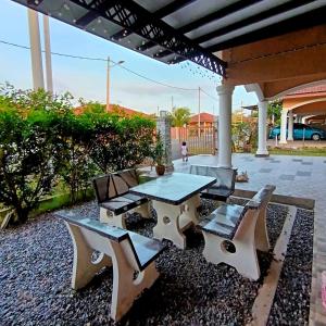 patio con tavolo e sedie sotto un tetto di Ebnur Homestay ad Arau