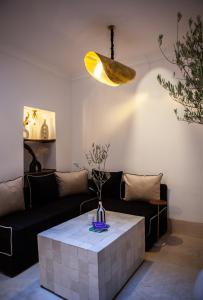 ein Wohnzimmer mit einem Sofa und einem Tisch in der Unterkunft Cosy Riad in Marrakesch