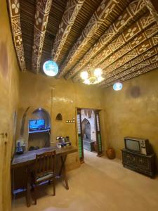 eine Küche mit einem Tisch und einem Waschbecken in einem Zimmer in der Unterkunft بيت النحوي التراثي _ Bait Al Nahwai in Al Hamra