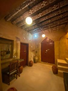 ein Zimmer mit einem Tisch und einer Bank in einem Zimmer in der Unterkunft بيت النحوي التراثي _ Bait Al Nahwai in Al Hamra