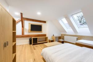 a attic bedroom with a bed and a tv at B&B Pri Peclju in Podgrad