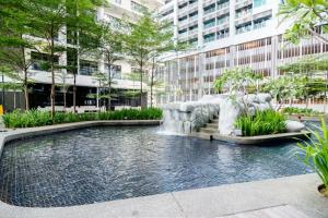 a pool with a waterfall in the middle of a city at 188 suites By Seng Home in Kuala Lumpur