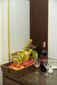einen Obstkorb und eine Flasche Wein auf dem Tisch in der Unterkunft Hà Thành Hotel - ngõ 63 Lê Đức Thọ - by Bay Luxury in Hanoi