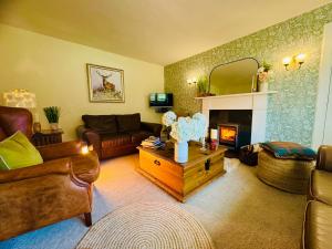 a living room with a couch and a fireplace at Rosemount Cottage TWO - Highland Cottage in Garve