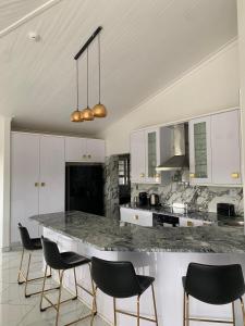 a kitchen with a marble counter and black chairs at Avis sunrise view in Windhoek
