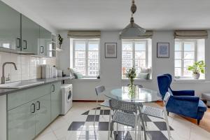 a kitchen with a glass table and blue chairs at Downtown Apartments Old Town Powroźnicza in Gdańsk