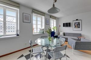 a living room with a glass table and chairs at Downtown Apartments Old Town Powroźnicza in Gdańsk
