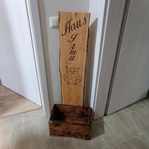 a wooden sign with a box next to a door at Haus Irma in Hemmingstedt