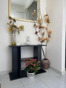 un tavolo da gioco nero con specchio e fiori di THE YELLOW HOUSE a Quartucciu