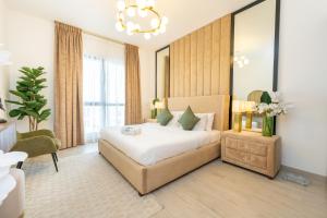 FAM Living - Serene 1BR Haven in Madinat Jumeirah Living في دبي: غرفة نوم بسرير كبير وثريا