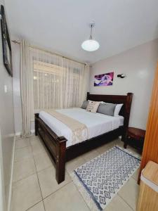 een slaapkamer met een groot bed en een raam bij 1 Bedroom Apartment on Kiambu Road in Kiambu