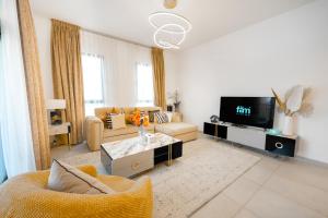 a living room with a couch and a tv at FAM Living - Serene 1BR Haven in Madinat Jumeirah Living in Dubai