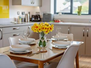 uma mesa de jantar com flores amarelas num vaso em 2 Bed in Westward Ho 91748 em Northam