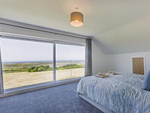 a bedroom with a large window with a view of the beach at 4 Bed in Appledore 91648 in Appledore