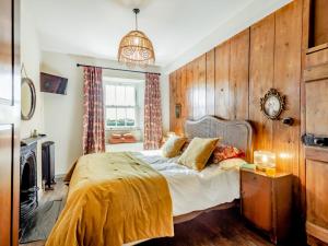 a bedroom with a bed with a wooden wall at 4 Bed in Abersoch 91656 in Bottwnog
