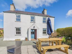 a house with a table and an umbrella in front of it at 4 Bed in Abersoch 91656 in Bottwnog