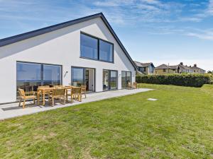 a white house with a patio and grass at 4 Bed in Appledore 91648 in Appledore