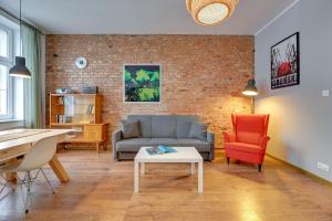 a living room with a couch and a chair at Downtown Apartments City Center Art House - Family Stay in Gdańsk