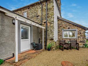 a stone house with a white door and a patio at 1 Bed in Matterdale 91812 in Dockray