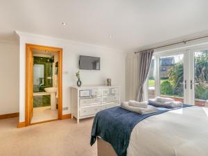 a white bedroom with a bed and a window at 4 Bed in Westward Ho 91814 in Northam