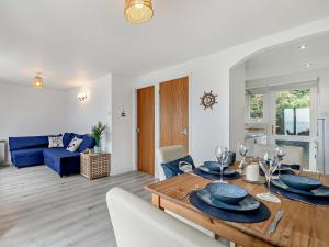 a living room with a table and a blue couch at 1 Bed in Plymouth 91835 in Turnchapel