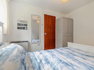 a bedroom with a bed and a wooden door at 1 Bed in Plymouth 91835 in Turnchapel