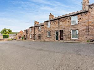 an old brick building with a street in front of it at 2 Bed in Wooler 92074 in Wooler