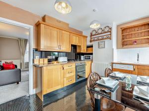 a kitchen with wooden cabinets and a dining table at 2 Bed in Wooler 92074 in Wooler