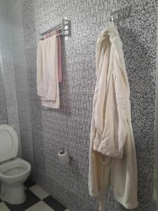 a bathroom with a toilet and towels on a wall at Dar yahya in Chefchaouene