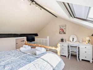 een slaapkamer met een bed, een bureau en een televisie bij 3 Bed in Kendal 91839 in Kendal