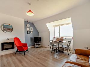 a living room with a red chair and a table at 2 Bed in Hornsea 91997 in Hornsea