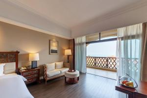 a hotel room with a bed and a balcony at Xiamen Royal Victoria Hotel in Xiamen