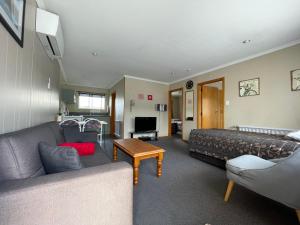 a living room with a couch and a table at Alexandra Motor Lodge in Alexandra