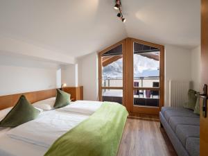 a bedroom with a bed and a couch and a window at Brixentalerhof in Westendorf