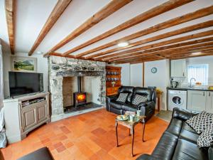 sala de estar con sofá y chimenea en 2 Bed in Aberdesach 92082 en Clynnog-fawr