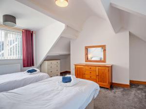 1 dormitorio en el ático con 2 camas y espejo en 2 Bed in Aberdesach 92082 en Clynnog-fawr
