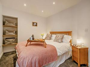 een slaapkamer met een bed met een tafel erop bij 2 Bed in Aberdovey 91962 in Aberdyfi