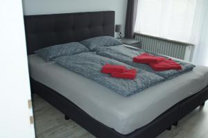a bed with two red pillows on it at RuheOase Oberriexingen - Wohlfühlen, abschalten und entspannen in Oberriexingen