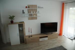 a living room with a flat screen tv on a wooden entertainment center at RuheOase Oberriexingen - Wohlfühlen, abschalten und entspannen in Oberriexingen