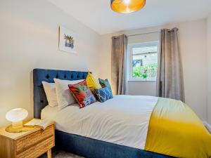 um quarto com uma cama com uma cabeceira azul e uma janela em 3 bed property in Gower South Wales 91727 