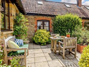 a patio with two chairs and a table in front of a house at 1 Bed in Crewkerne 91795 in West Chinnock