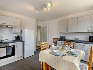 eine Küche und ein Esszimmer mit einem Tisch und Geräten in der Unterkunft 2 Bed in Tenbury Wells 91980 in Mamble
