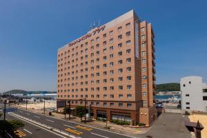 a tall brown building on the side of a road at Shimonoseki Station West Washington Hotel Plaza in Shimonoseki