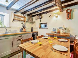 une cuisine avec une table et des chaises en bois ainsi qu'une cuisine avec un comptoir dans l'établissement 2 Bed in Glenridding 92087, à Glenridding