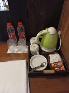 ein Tablett mit einem Wasserkocher, Tellern und Wasserflaschen in der Unterkunft Ti Amo Bali in Jatiluwih